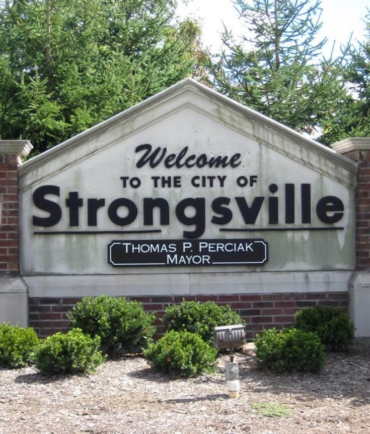 Welcome sign for the City of Strongsville, Ohio, with greenery and trees in the background, featuring the name of Mayor Thomas P. Perciak.