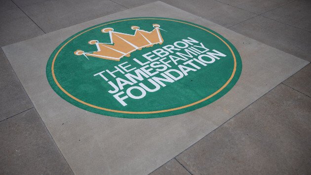 The LeBron James Family Foundation logo displayed on a green circular floor decal, featuring a gold crown above the foundation's name in white text.